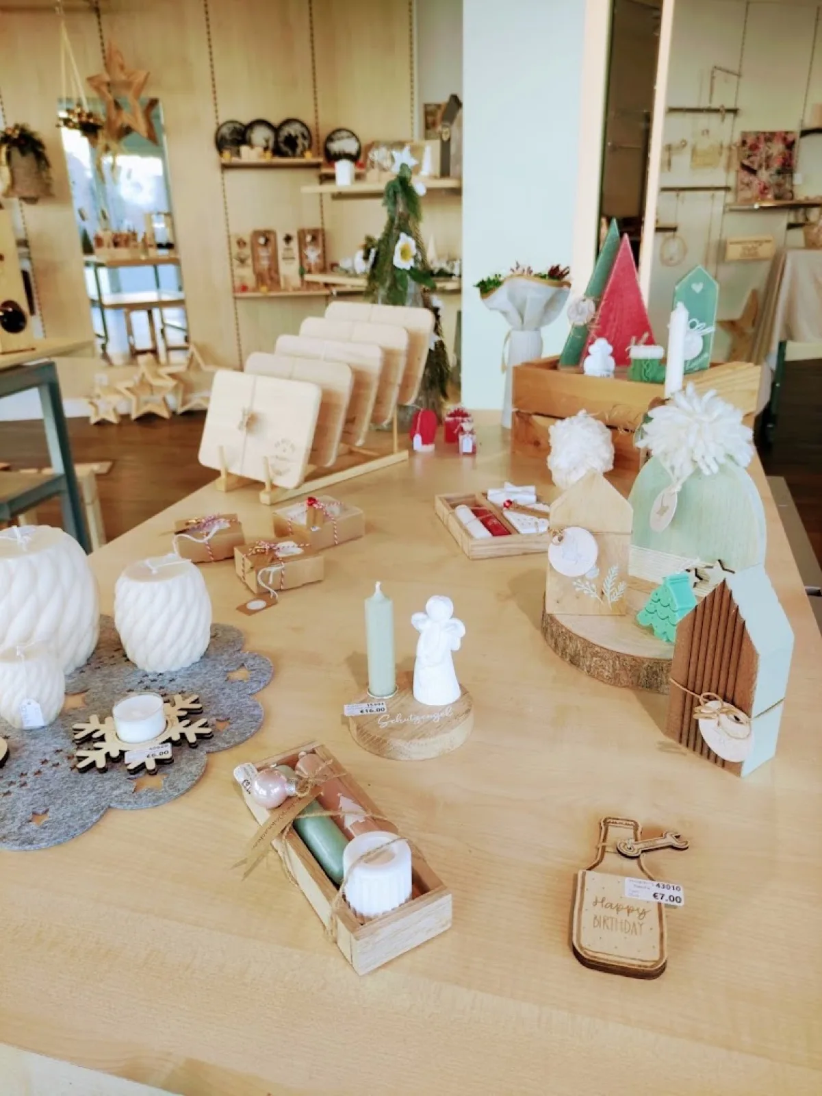 Tisch mit Kerzen, Holzobjekten und Geschenkverpackungen im Pop-up-Store