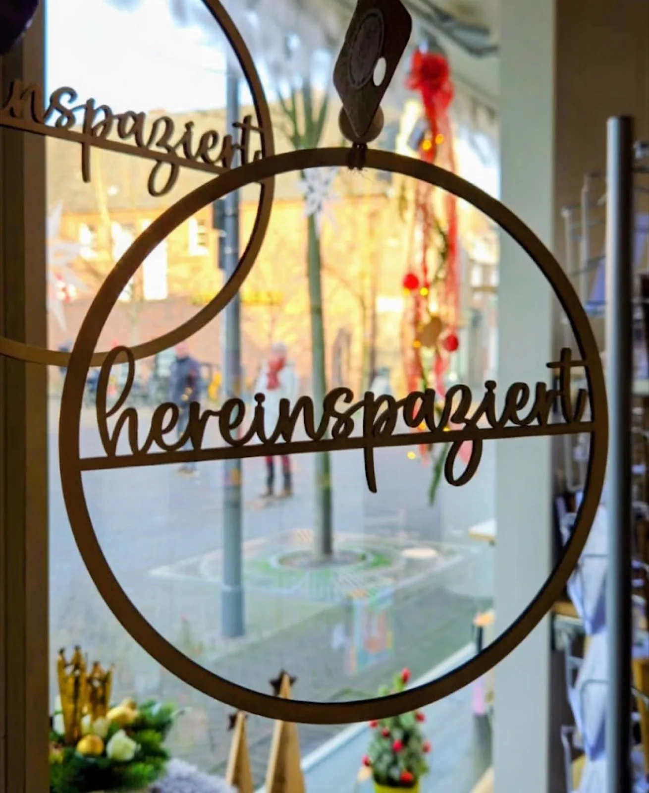 Holzschild mit der Aufschrift hereinspaziert im Schaufenster